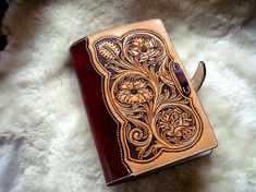 a brown and black leather book sitting on top of a white furnishing covered floor