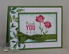 a thank you card with red flowers and green ribbon on the bottom, in front of a white background