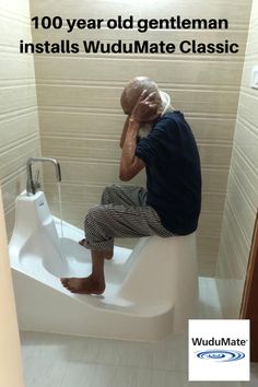 a man sitting on top of a toilet with his head in his hands and the words, 100 year old gentleman installs wudumate classic