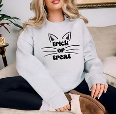 This super cute and trendy Halloween Sweatshirt would be perfect for spooky season this year, curl up on the couch, watch your favorite spooky movie and get cozy! Without a doubt, you will be amazingly comfortable and so beautiful in this Cat Face Trick or Treat Sweatshirt! ♥ UNISEX CREWNECK SWEATSHIRT ♥ You will need to add each sweater individually to your cart and go through the personalization process for each to specify your required notes for each :)     ♥ HOW TO ORDER ♥ 1. Make selections Casual Cat Design Sweatshirt For Fall, Halloween Cat Face, Cat Face Halloween, Trendy Fall Sweatshirt With Cat Design, Halloween Cat Print Crew Neck Top, Halloween Cat Print Crew Neck Sweatshirt, Casual Halloween Cat Design T-shirt, Spooky Movies