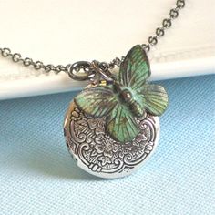 Small Silver Locket Necklace - Decorative Small Silver Ox Locket accented with a Verdigris Brass Butterfly. The Locket is 20 mm (slightly smaller than US nickel) and has a floral pattern. Stainless Steel Chain The patina on the butterfly will vary slightly from the one pictured. For other locket designs: http://www.etsy.com/shop/mcstoneworks/search?search_query=locket&search_submit=&search_type=user_shop_ttt_id_5402200&shopname=mcstoneworks Green Charms Jewelry Perfect For Gifts, Green Vintage Charm Jewelry For Gift, Green Vintage Charm Jewelry Gift, Turquoise Locket For Wedding Jewelry, Turquoise Locket Jewelry For Wedding, Turquoise Wedding Locket Jewelry, Adjustable Vintage Charm Jewelry For Anniversary, Whimsical Green Nickel-free Jewelry, Silver Butterfly Necklace For Birthday