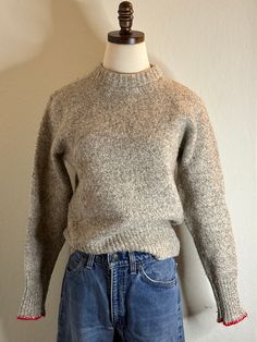 a mannequin wearing a gray sweater and jeans