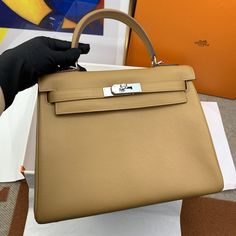 Description HRMS Kelly 28 Evercolor Gold Bag For Women, Handbags, Shoulder Bags 11in/28cm Rep 1:1 Hermès bags are considered the ultimate luxury item worldwide. Each piece is handcrafted with waitlists that can exceed a year or more. The streamlined and demure Kelly style is always in high demand; it is particularly lovely in this vibrant version with silver hardware. Evercolor is textured with a wonderful grainy appearance. Evercolor is soft to the hand and maintains the shape of the bag well o Dior Bucket Hat, Chanel Coco Handle, Hermes Kelly 28, Book Tote Bag, Chanel Tote, Gold Bag, Stylish Handbags, Luxury Products, Hermes Bags