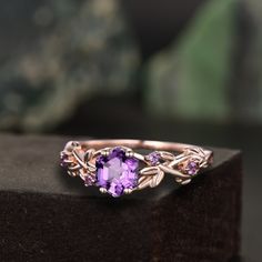 a ring with an amethorate stone in the center and leaves around it