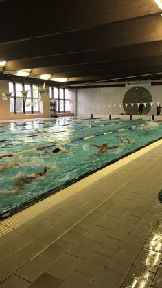 an indoor swimming pool with people in it