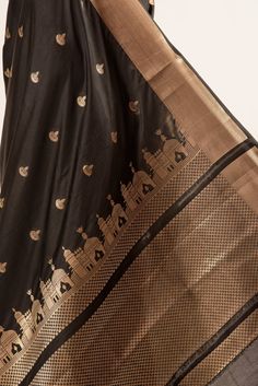 Beautiful Black Katan Silk Banarasi Saree, meticulously crafted with a lustrous gold zari Temple border and exquisitely detailed pallu. Adorned with intricate zari bootas across its body, this saree radiates with sophistication. Feel the luxury with its soft-to-touch fabric, perfect for making a graceful statement at any festivity. Black Brocade Dupatta With Zari Work, Gold Brocade Traditional Wear With Drape, Festive Gold Traditional Wear For Ceremonies, Gold Traditional Wear In Art Silk, Traditional Gold Silk Wear, Gold Traditional Wear With Meenakari For Transitional Season, Traditional Gold Silk Traditional Wear, Gold Traditional Wear With Patterns For Diwali, Gold Traditional Wear With Patterns For Eid