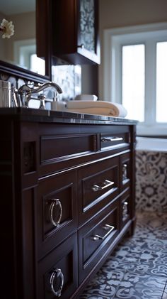 a bathroom with a sink, mirror and tiled flooring in dark wood color scheme