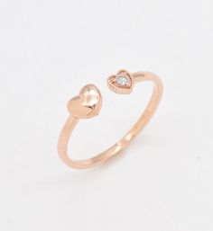 a rose gold ring with two hearts on the front and one heart on the back