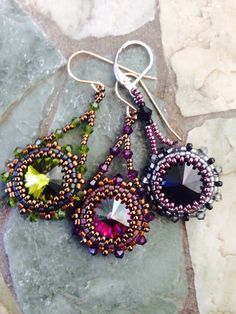 two pairs of beaded earrings sitting on top of a rock