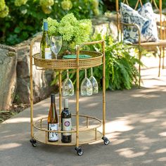 a table with wine bottles and glasses on it in the middle of a patio area