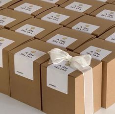 many brown boxes with white bows and labels on them