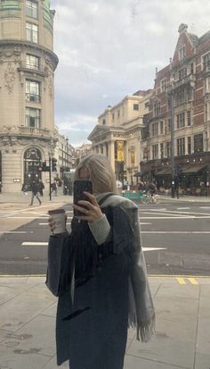 a woman taking a selfie with her cell phone on the side of the road