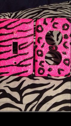 two pink and black zebra print light switch covers on top of a zebra print blanket