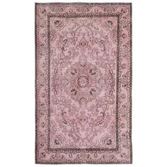 a pink rug with an intricate design on the center and sides, in front of a white background