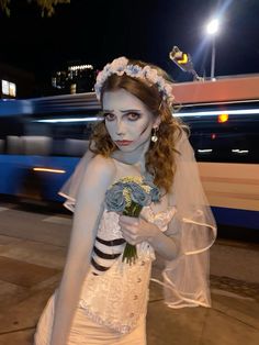 a woman with makeup and make - up is standing on the street holding a bouquet