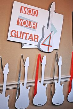 the guitar magnets are hanging on the wall next to each other and have scissors attached to them