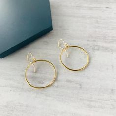 Simple gold circle drop earrings. These stylish earrings are the perfect accessory to compliment your look.Earrings you'll love to wear or love to give.Matching necklace available.DETAILS:+ Quality earrings and charm in 14k gold filled+ Wire hook earrings (hanging length 20mm)+ Circle approximately 25mm+ Gift-ready in our stylish white KookyTwo box+ Handmade by us in our UK studio+ FREE UK DELIVERY14K Gold Filled jewellery is made of a solid layer of gold (14k), permanently bonded to a base meta Gold Circle Earrings, Gold Drop Necklace, Earrings Hanging, Circle Jewelry, Stylish Earrings, Hippie Earrings, Halo Earrings, Box Handmade, Gold Circle