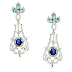 Introducing our exquisite Chandelier Earrings, a luxurious tribute to European elegance and opulence. Inspired by the grandeur of classic European chandeliers mixed with nature motifs, these stunning earrings are adorned with 3.05 carats of sparkling white round diamonds, creating a dazzling cascade of light and brilliance. Adding a rich depth of color are two oval-shaped blue sapphires totaling 3.46 carats, complemented by six oval-shaped apatites totaling 1.46 carats, which enhance the earrings' vibrant allure. Crafted in 18K white gold and weighing 18.42 grams, these earrings exude sophistication and timeless beauty. Perfect for any special occasion, these Chandelier Earrings are designed to make a statement with their intricate craftsmanship and radiant colors. Embrace the elegance and European Modern, European Elegance, Nature Motifs, Big Diamond, Jewel Box, Sapphire Earrings, Stunning Earrings, Dream Jewelry, Chandelier Earrings