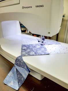 a close up of a sewing machine with a piece of fabric on the table next to it