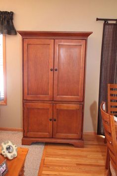 a wooden cabinet sitting in the corner of a room