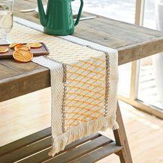 a table with an orange slice on it and a green pitcher sitting next to it