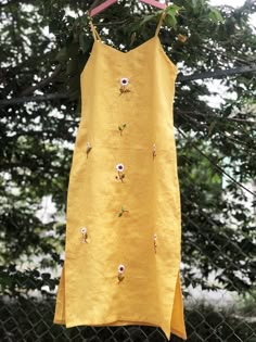 ❤ The yellow linen hand embroidered dress is very soft, skin friendly, breezy and comfortable.  ❤ Item description: - A lovely dress with embroidered daisy flowers motifs. - Suitable for hot summer. - Material: linen, button, embroidery threads. - Environmentally friendly. - This dress is very useful, go with any outfit, that can be used to go out, go shopping...    It is a perfect gift for yourself or your beloved.  ❤ Care instructions:      The best way to wash embroidery cloth is to put it in soapy water (with a mild detergent and cold water at 86 ºF/30oС) for 20 minutes. Try to not wash the item with other clothing that might cause damage, such as zippers, buttons or different colors. You wash it by hand, and if you have dirty patches on your garment, you can gently rub them, it's best Daisy Embroidered Dress, Dress With Hand Embroidery, Linen Dress Embroidery Ideas, Embroidery In Clothes, Yellow Embroidered Summer Beach Dress, Yellow Beach Dress With Floral Embroidery, Linen Dress Embroidery, Hand Embroidery Clothes, Summer Embroidery Designs