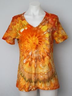 an orange and yellow tie dye shirt on a mannequin head stand with white torso