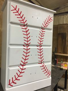 a baseball themed dresser is painted white with red stitches on the top and bottom part