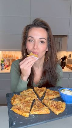 a woman sitting in front of a tray with food on it and looking at the camera