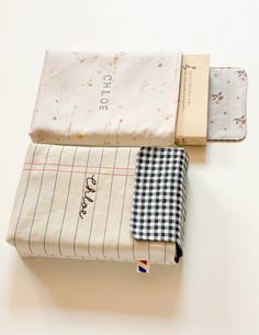 three folded cloths sitting next to each other on top of a white tablecloth