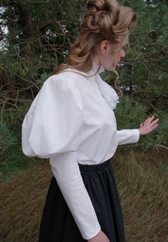 All cotton blouse with leg-o-mutton sleeves, lace ruffled collar and attached jabot, pintuck detailing on the front, back button closure. Hand or machine wash cold and tumble dry low or hang to dry. By Recollections and made in America. The model is wearing a skirt and it is priced separately. The following are approximate finished measurements and include room for ease of movement. Bust (in inches) XS37 S40 M44 L47 XL51 XXL56 3XL59 4XL63 Edwardian Blouse, Memorial Weekend, Womens Blouses, Ruffled Collar, Cotton Blouse, Lace Ruffle, Pin Tucks, Custom Dresses, Hawks