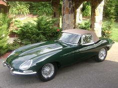 a green sports car parked in front of a house