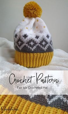 a crocheted hat with a pom - pom sitting on top of it