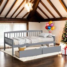 a bedroom with a bed, christmas tree and presents on the floor in front of it