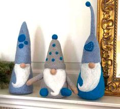 three gnomes sitting on top of a mantle next to a mirror