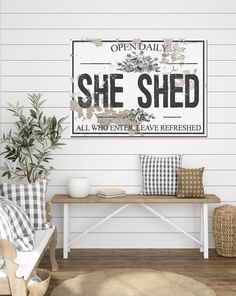 an open day she shed sign hangs on the wall above a bench with pillows and blankets