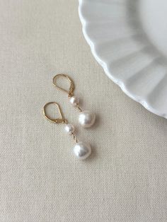 Never underestimate the power of a simple pearl drop earring! These double baroque pearl earrings look as beautiful on your special day as they do glamming up any casual outfit. They are sure to become a favorite go to accessory! * Natural 6mm and 10mm off-round white Baroque Pearls * 14K Gold Filled or 925 Sterling Silver 17mm Leverback clasp * 1.5 inch length * Made with all hypoallergenic materials 🤍 *Please note for the health and safety of my customers, and to uphold the highest quality standards - these earrings are final sale - please dm me with any questions prior to purchase 😊 ✨ Shop all Pearl earrings here!: https://etsy.me/3Xiy4c5 GET TO KNOW MAGBEE JEWELRY! ✨  🤍 All MagBee pieces are safe for sensitive skin and made with hypoallergenic Gold Filled or 925 Sterling Silver. 🤍 Cheap Dangle Earrings With Pearl Charm, Simple Pearl Earrings, Bridal Pearl Earrings, Drop Earrings Bridal, Pearl Drop Earrings Bridal, Freshwater Pearl Drop Earrings, Earrings Double, Simple Pearl, Basic Jewelry