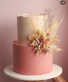 there is a pink and white cake with flowers on it