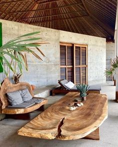 a large wooden table sitting next to two chairs and a potted plant on top of it