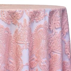 a pink table cloth with an intricate lace design on it's edges and bottom