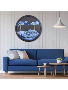 a living room with a blue couch and coffee table in front of a painting on the wall