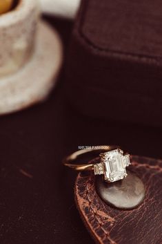 an engagement ring sitting on top of a piece of wood