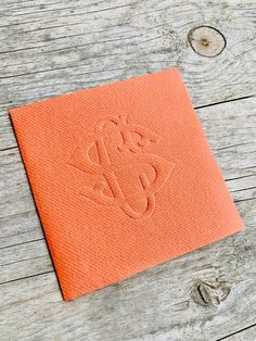 an orange piece of cloth with the word love on it sitting on top of a wooden table