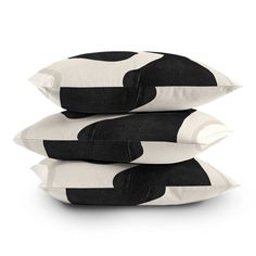 three black and white pillows stacked on top of each other