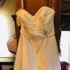 a white wedding dress hanging on a rack