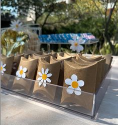 some brown paper bags with white and yellow flowers on them are sitting on a table