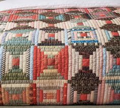 a bed with a colorful quilt on top of it