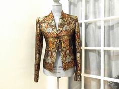 Rare Find! Beautiful silk metallic brocade blazer by designer Richard Tyler 'Collection' Brown and gold silk jacquard blazer Shoulders are lightly padded, the sleeves are finished off tithe black buttons, the waist is fitted for a flattering fit, and the inside is fully lined Dimensions Length: 22 in. (55.88 cm)Marked Size: M (US)Bust: 38 in. (96.52 cm)Waist: 32 in. (81.28 cm) Condition: "very good pre-loved vintage condition - see pictures" Fabulous present!!  This item is ready to ship and we Gold Fitted Luxury Blazer, Luxury Brocade Fitted Blazer, Fitted Brocade Blazer For Party, Designer Tailored Gold Blazer, Brocade Long Sleeve Party Blazer, Brocade Long Sleeve Blazer For Party, Brocade Blazer With Long Sleeves For Parties, Fitted Jacquard Blazer With Long Sleeves, Evening Jacquard Fitted Blazer