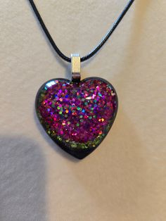 Pretty black resin heart pendant with crushed glass in purple and green tones with hints a teal. Silver toned alloy bail with an 18" black, waxed cotton necklace that has a 2" extender attached. Comes to you sealed in protective wrap in a cute gift box. Cotton Necklace, Cute Gift Boxes, Crushed Glass, Black Resin, Great Gifts For Mom, Resin Earrings, Green Tones, Waxed Cotton, Earring Necklace