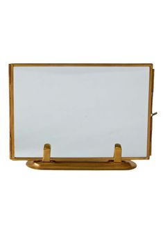 an empty white board on a stand with two gold handles and no one around it